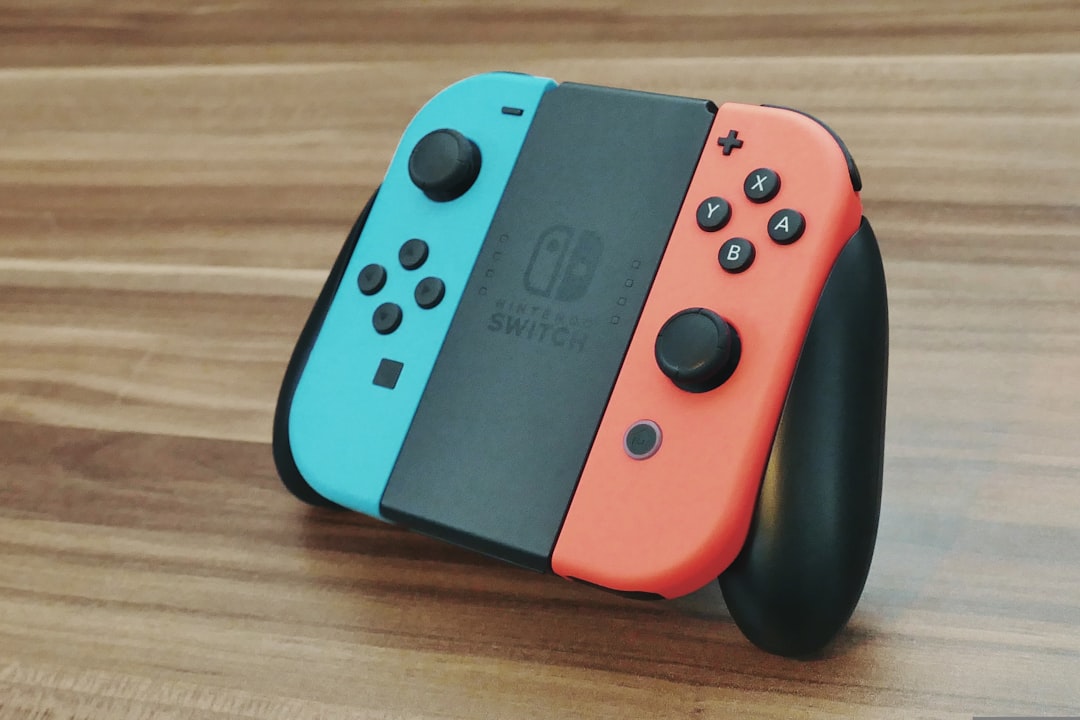 a couple of nintendo wii controllers sitting on top of a wooden table