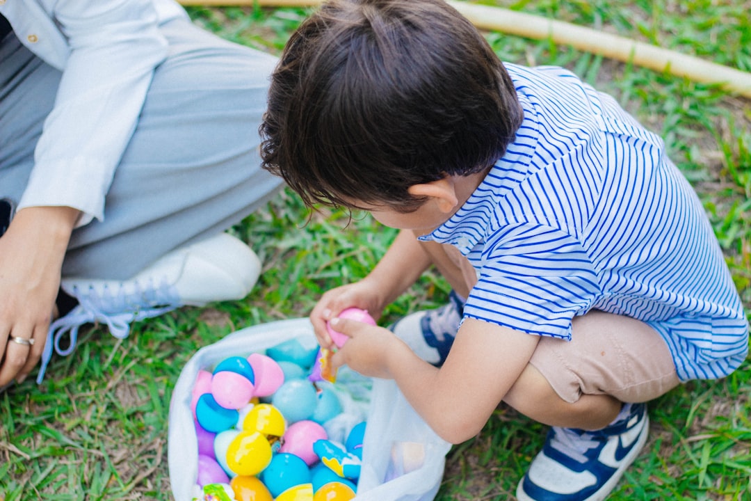 a little boy playing with a bucket of easter eggs
